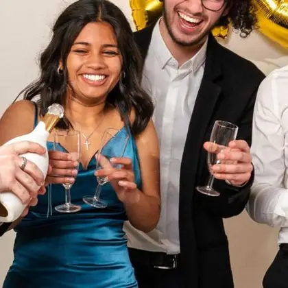 Invités en tenue de soirée qui trinquent devant le photobooth